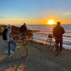 travelers-with-bikes-watching-sunset-near-ocean-beach-california-dreams-hostel
